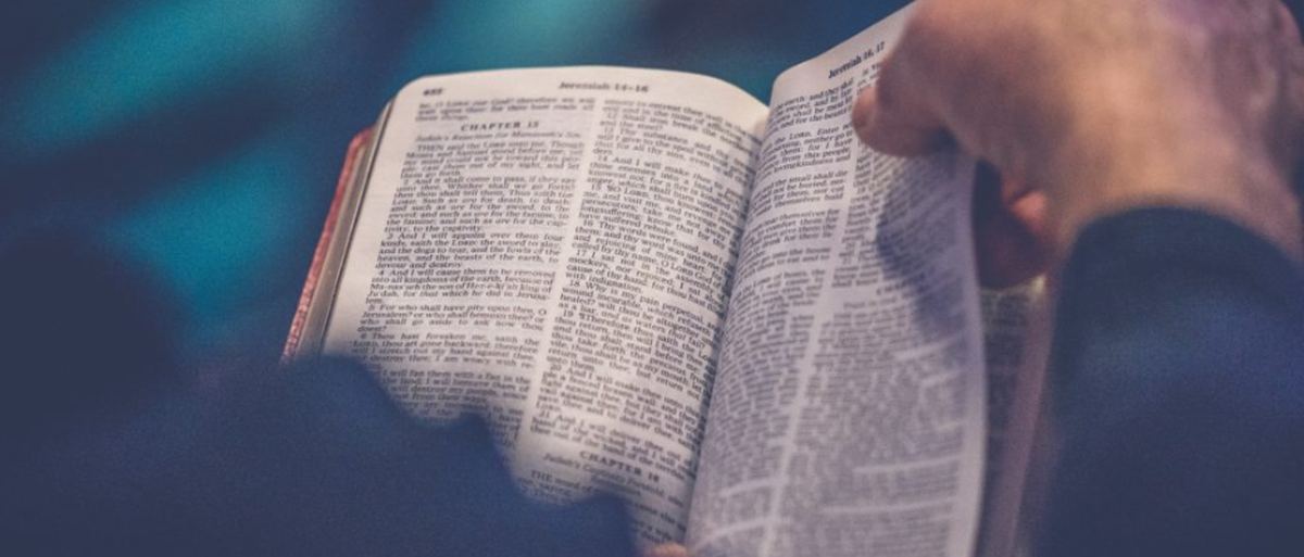 Une main tournant les pages d'une Bible ouverte
